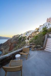 a patio with chairs and a view of the ocean at Oia Waves by SV in Oia