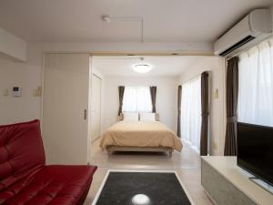1 dormitorio con cama, sofá y TV en Dolcevita, en Ginoza