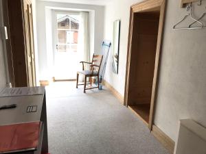 a room with a kitchen with a chair and a door at Apartment Walter in Vals