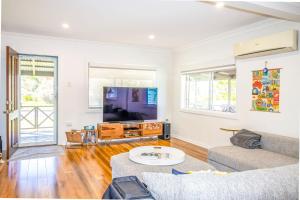 a living room with a couch and a tv at A Wave from it All in Berrara