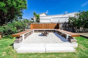 a backyard with a picnic table and a bench at A Wave from it All in Berrara