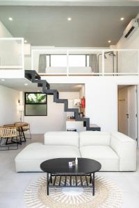 ein Wohnzimmer mit einer weißen Couch und einer Treppe in der Unterkunft Tropicana Loft Canggu in Canggu