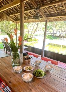 a wooden table with bowls of food on it at Homie Hava Homestay in Lang Co