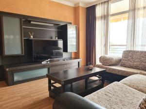 - un salon avec un canapé, une table et une télévision dans l'établissement 1HAB en Castillo Santa Clara, à Torremolinos