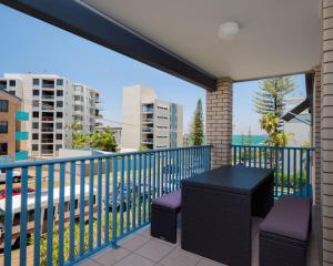 a balcony with a black table and two chairs at Levuka Unit 12 14 Moreton Pde in Caloundra