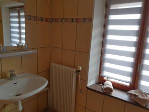 a bathroom with a sink and a mirror and a window at Guestroom Ventron, 1 pièce, 3 personnes - FR-1-589-567 in Ventron