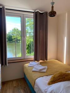 a bedroom with a bed and a window with a view at Las i woda in Przywidz