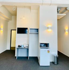 an empty office with a refrigerator and a table at Gamma Hotel in Auckland