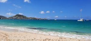 a view of a beach with a boat in the water at Chambre d'hôte chez Aurélie et Jean-Christophe in Simpson Bay