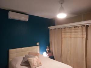 um quarto com uma cama e uma parede azul em Chambre d'hôte chez Aurélie et Jean-Christophe em Simpson Bay