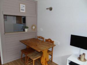 een eetkamer met een houten tafel en stoelen bij Studio Valfréjus, 1 pièce, 3 personnes - FR-1-561-52 in Valfréjus