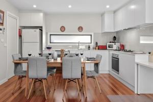 - une cuisine avec une table et des chaises en bois dans l'établissement StayCentral - Thornbury Entertainer Townhouse, à Melbourne