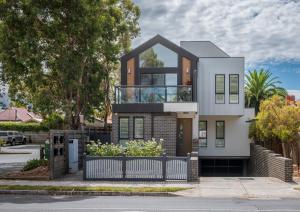 une maison avec un balcon en verre dans une rue dans l'établissement StayCentral - Thornbury Entertainer Townhouse, à Melbourne
