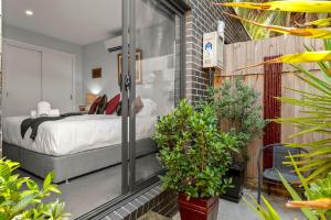 - une chambre avec un lit et des plantes dans l'établissement StayCentral - Thornbury Entertainer Townhouse, à Melbourne