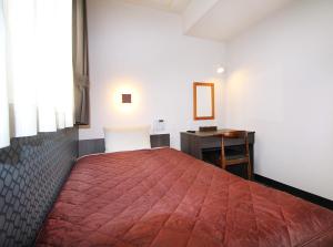 大阪市にあるホテルトレンド西心斎橋のベッドルーム(赤い大型ベッド1台、デスク付)