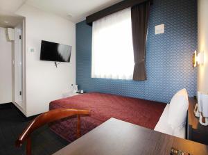 大阪市にあるホテルトレンド西心斎橋の赤いベッドと窓が備わるホテルルームです。