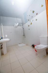 a bathroom with a toilet and a sink at Le "Grand Bleu", un bel appartement paisible, sûr et spatieux au cœur de la station balnéaire de Saly Portudal in Saly Portudal
