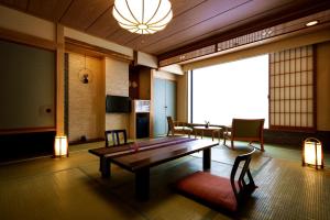 sala de estar con mesa de madera y sillas en Aburaya Tousen, en Yamanouchi