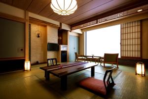 a living room with a wooden table and chairs at Aburaya Tousen in Yamanouchi