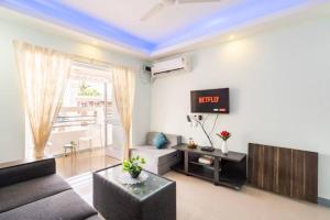 a living room with a couch and a tv at 'Escape to the heavens with our sky view' 1BhK apartment,WIFI, Gym, pool & 5 min walk to Colva Beach in Colva