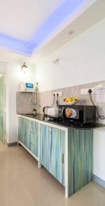 a kitchen with a microwave on top of a counter at 'Escape to the heavens with our sky view' 1BhK apartment,WIFI, Gym, pool & 5 min walk to Colva Beach in Colva