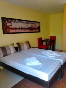 a large bed in a room with a sign on the wall at VF Riton Apartelle anex in Laoag
