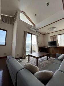 uma sala de estar com um sofá e uma mesa em Kitaizu North Private House - Vacation STAY 14216 em Numazu