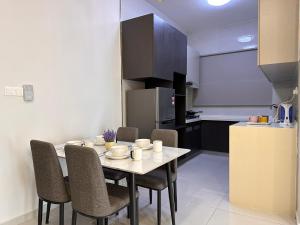 a kitchen with a table with chairs and a whiteboard at Country Garden Cozy 2 Bedroom @ By Hauz Cinta in Johor Bahru