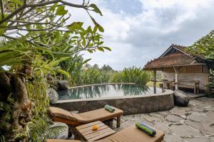 podwórko z basenem i domem w obiekcie Joglo Organik Guesthouse w mieście Ubud