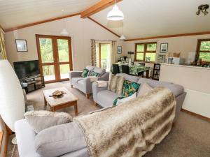 a living room with couches and a tv at The Beeches in Narberth