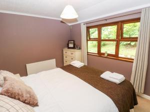 a bedroom with a large bed and a window at The Beeches in Narberth