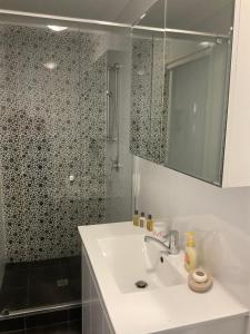 a bathroom with a sink and a shower with a mirror at Como Retreat - two bedroom villa in Perth