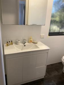 a bathroom with a white sink and a mirror at Como Retreat - two bedroom villa in Perth