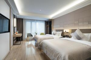 a hotel room with two beds and a desk at Morning Hotel, Changsha Yanghu New City Metro Station in Changsha