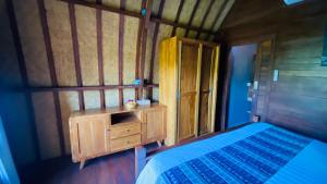 een slaapkamer met een bed en een houten kast bij Pondok sari homestay in Ungasan