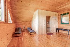 an empty room with two chairs in a wooden room at Ranch Stojnšek House With Sauna - Happy Rentals in Rogaška Slatina