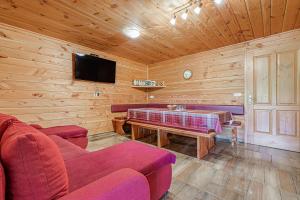 sala de estar con sofá, mesa y TV en Ranch Stojnšek House With Sauna - Happy Rentals, en Rogaška Slatina