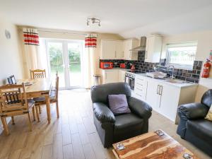 a kitchen and dining room with a table and a couch at Westerby Lodge in Claythorpe