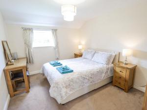 a bedroom with a bed and two night stands and a window at Westerby Lodge in Claythorpe