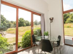 BroadweyにあるBudmouthの窓付きの客室で、ガラスのテーブルと椅子が備わります。