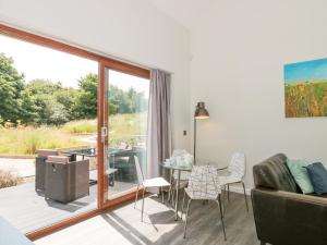 ein Wohnzimmer mit einem Balkon mit einem Tisch und Stühlen in der Unterkunft Bramshurst in Broadwey