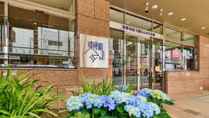a building with flowers in front of a building at Toyoko Inn Osaka Namba Nippombashi in Osaka