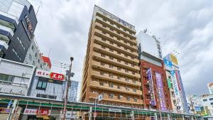 a tall building in the middle of a city at Toyoko Inn Osaka Namba Nippombashi in Osaka