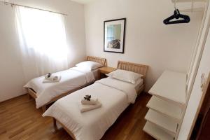 three beds in a room with white sheets and a window at Rosa apartment Mirca in Mirce