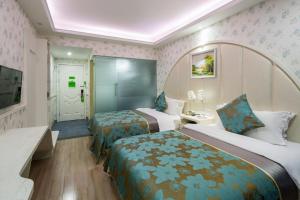 a hotel room with two beds and a tv at Morninginn, Radio and Television Center Xianglong Metro Station in Xingsha +7 photos