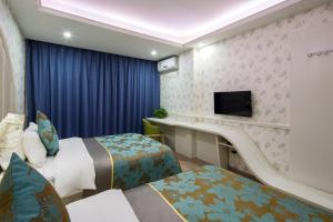 a hotel room with two beds and a tv at Morninginn, Radio and Television Center Xianglong Metro Station in Xingsha