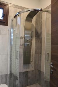 une douche avec une porte vitrée dans une salle de bain dans l'établissement The Romance # 01, à Kavala