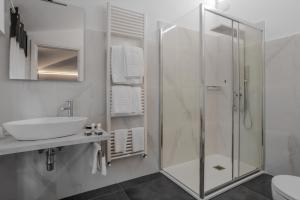 uma casa de banho com uma cabina de duche em vidro e um lavatório. em Albergo Alassio em Montecatini Terme
