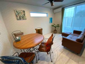 a living room with a table and a couch at Pleasure Point Ichinomiya in Ichinomiya