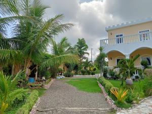 a house with palm trees and a driveway at The Ivory Castle in Pooc
